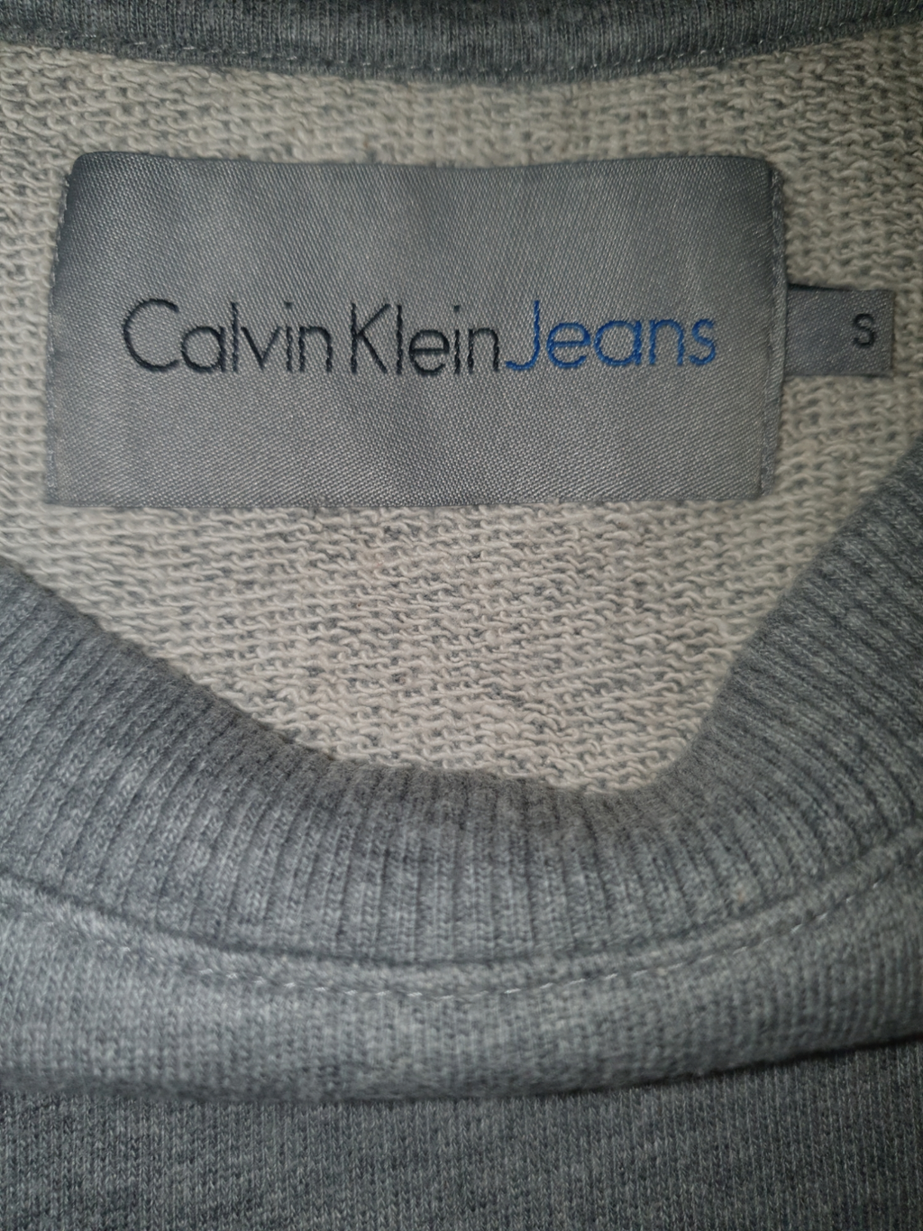 Calvin Klein Jeans grey label on knit sweater collar, size small, designer menswear