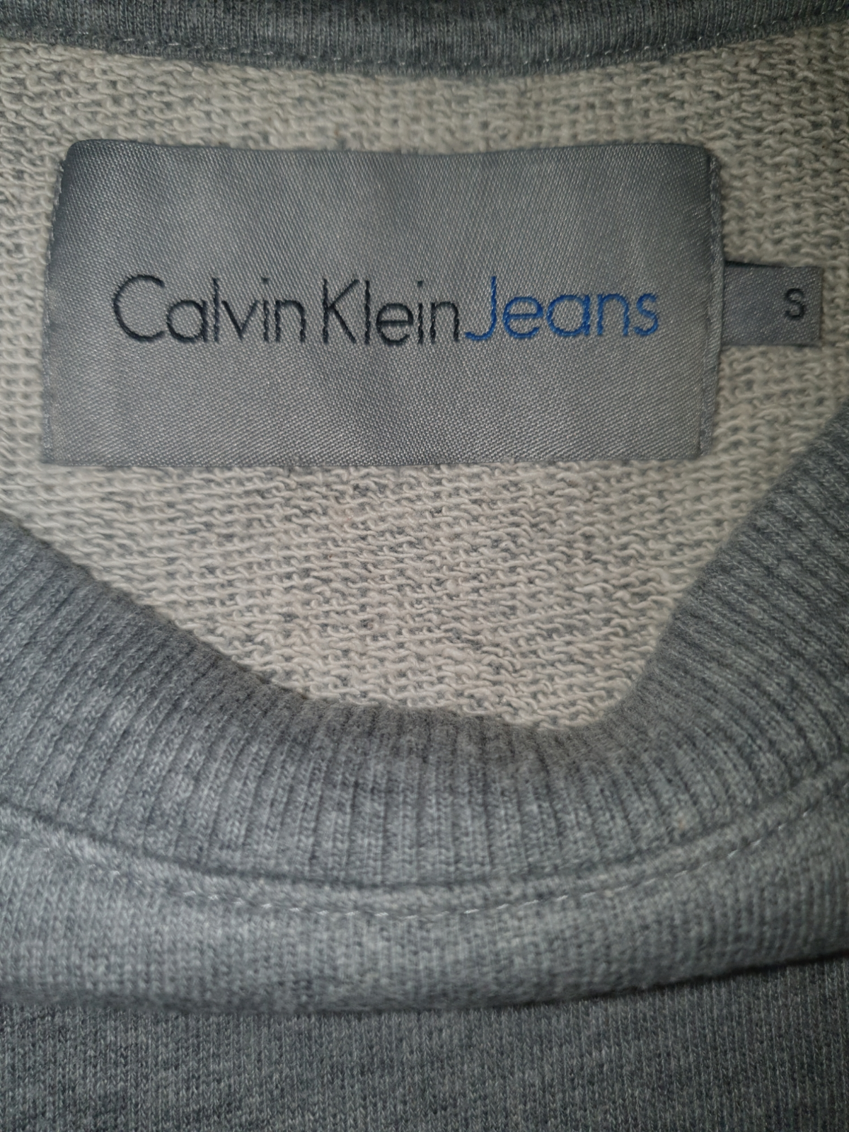Calvin Klein Jeans grey label on knit sweater collar, size small, designer menswear