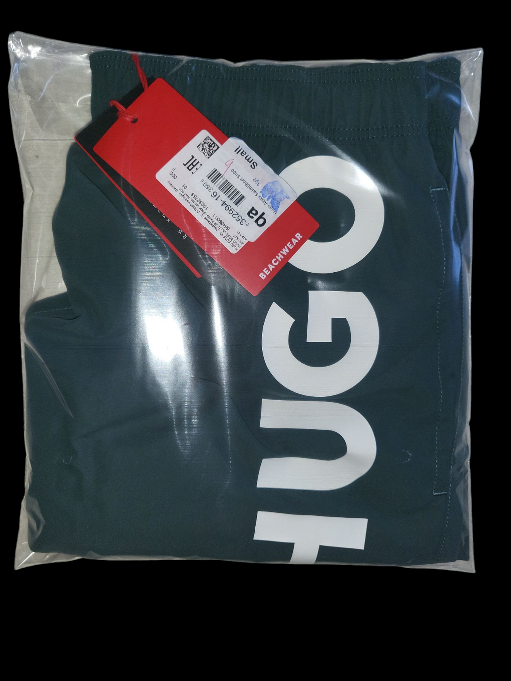 Packaged dark swim shorts with bold white lettering and red retail tag, size small