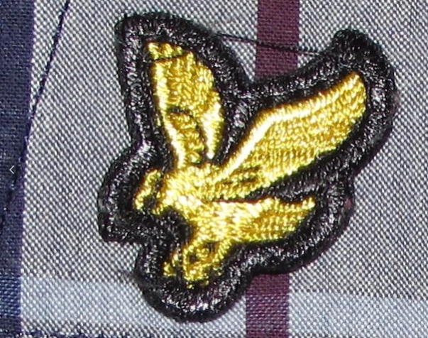 Yellow embroidered bird patch on plaid fabric, designer menswear detail