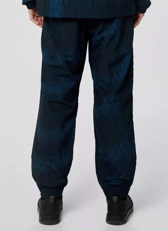 Men's navy blue patterned track pants with elastic cuffs, shown from the back