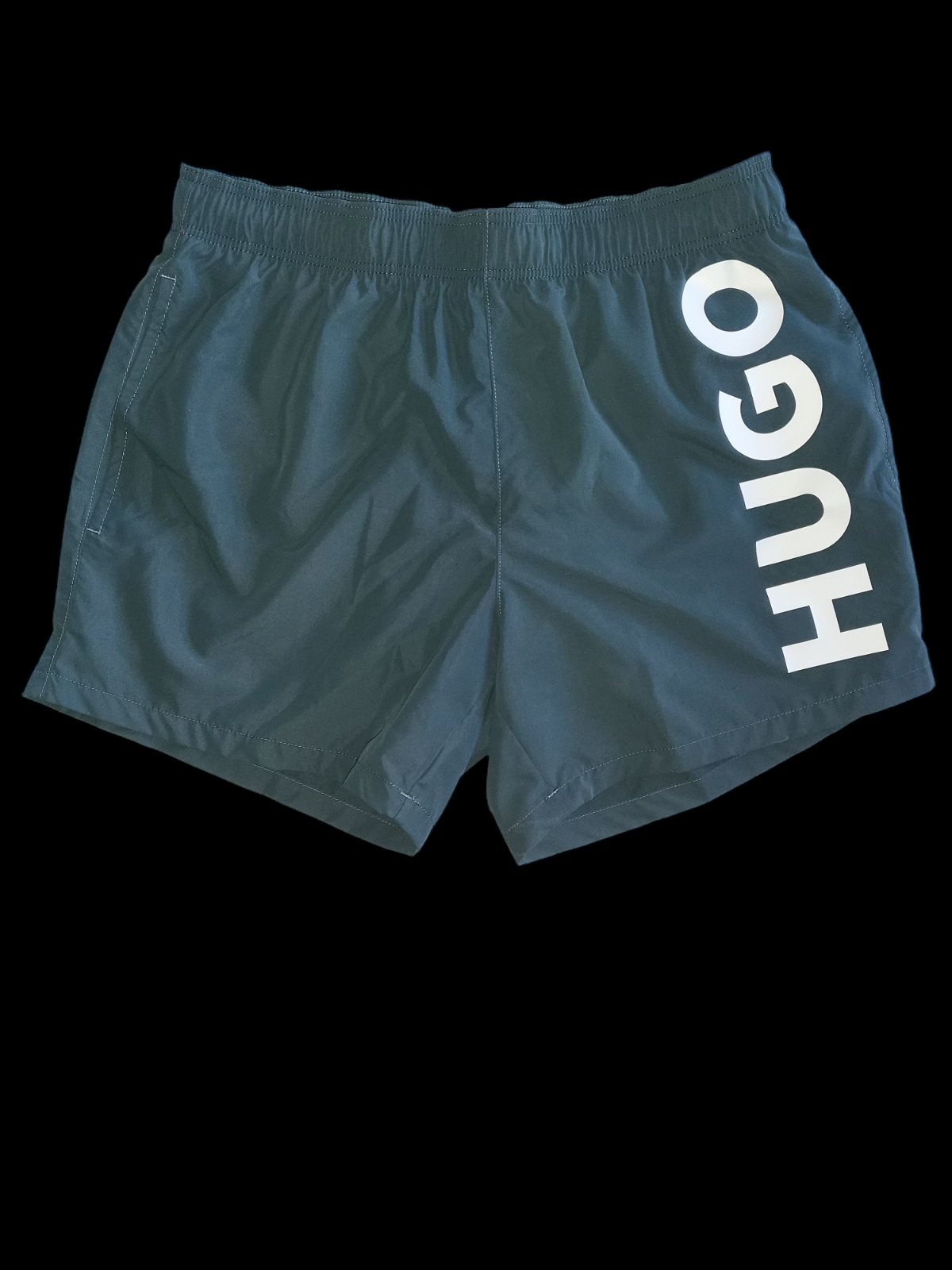 Men's black designer swim shorts with bold white HUGO logo on the left leg