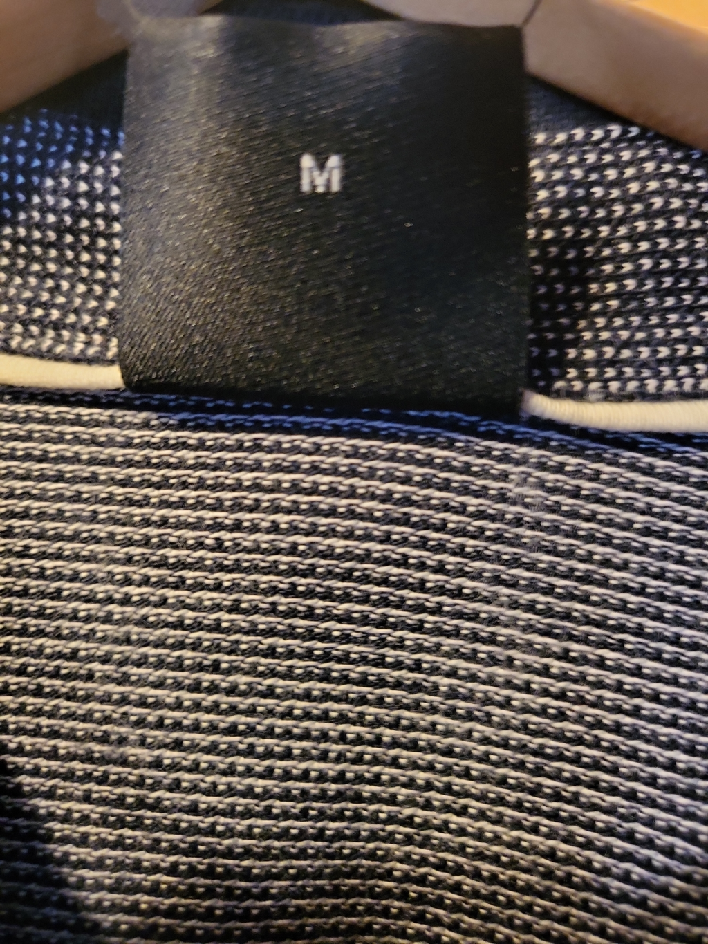 Medium size label on textured black and white knit men's clothing